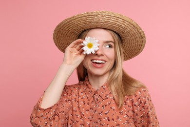 Beautiful woman with spring flower in hand on pink background