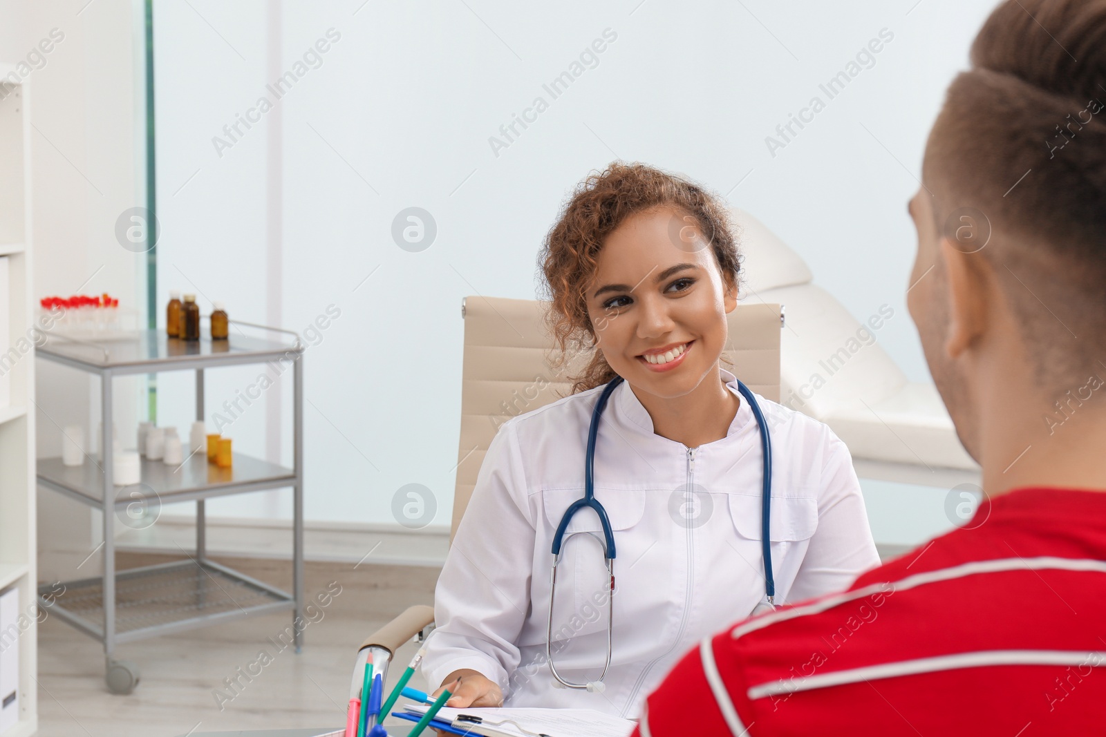 Photo of African American doctor working with patient in hospital