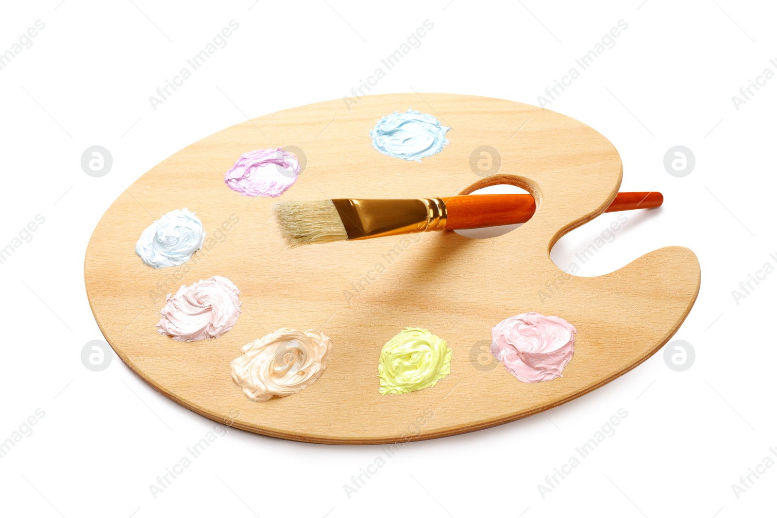 Photo of Wooden artist's palette with samples of pastel paints and brush on white background