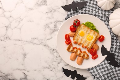 Cute monster sandwich with cherry tomatoes, fried eggs and sausages on white marble table, flat lay and space for text. Halloween snack