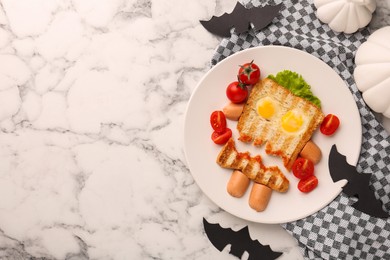 Photo of Cute monster sandwich with cherry tomatoes, fried eggs and sausages on white marble table, flat lay and space for text. Halloween snack