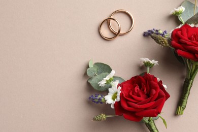 Photo of Small stylish boutonnieres and rings on beige background, flat lay. Space for text