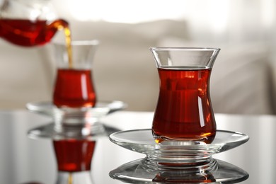 Photo of Glass of traditional Turkish tea on table indoors, space for text