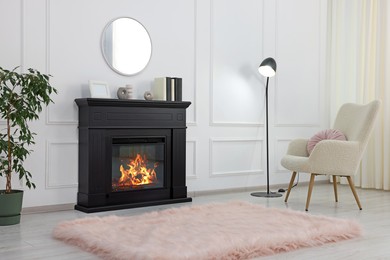 Black stylish fireplace near soft armchair, lamp and potted plant in cosy living room