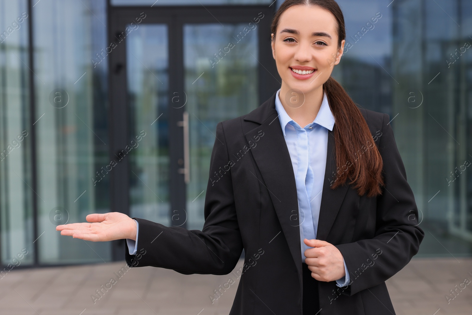 Photo of Happy real estate agent in suit outdoors