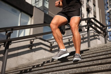 Photo of Man running down stairs outdoors on sunny day, closeup. Space for text