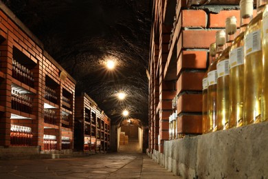 Beregove, Ukraine - June 23, 2023: Many bottles of alcohol drinks on shelves in cellar, low angle view