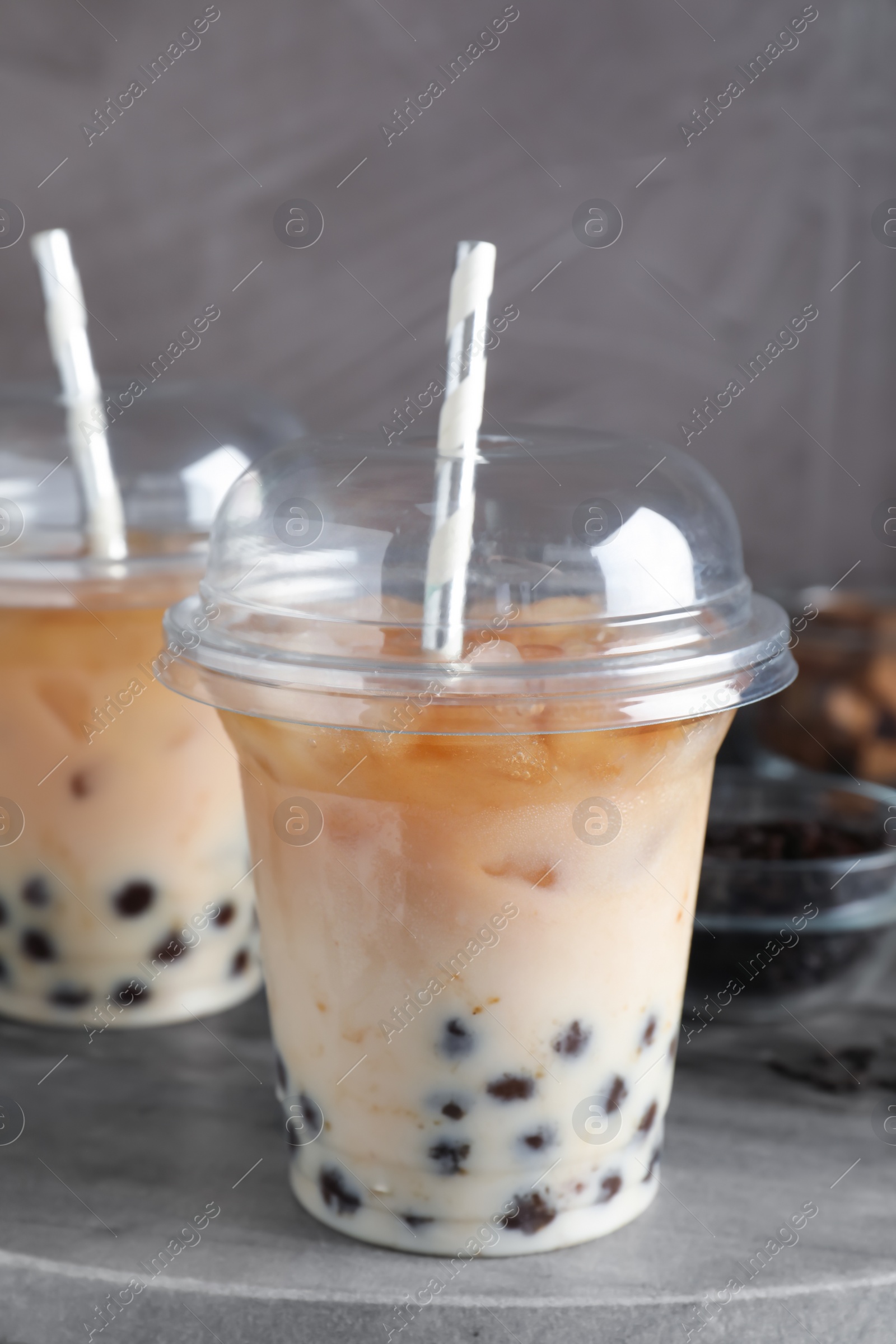 Photo of Tasty milk bubble tea on grey board, closeup