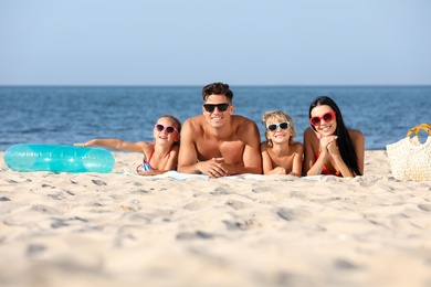 Photo of Happy family on sandy beach near sea. Summer holidays