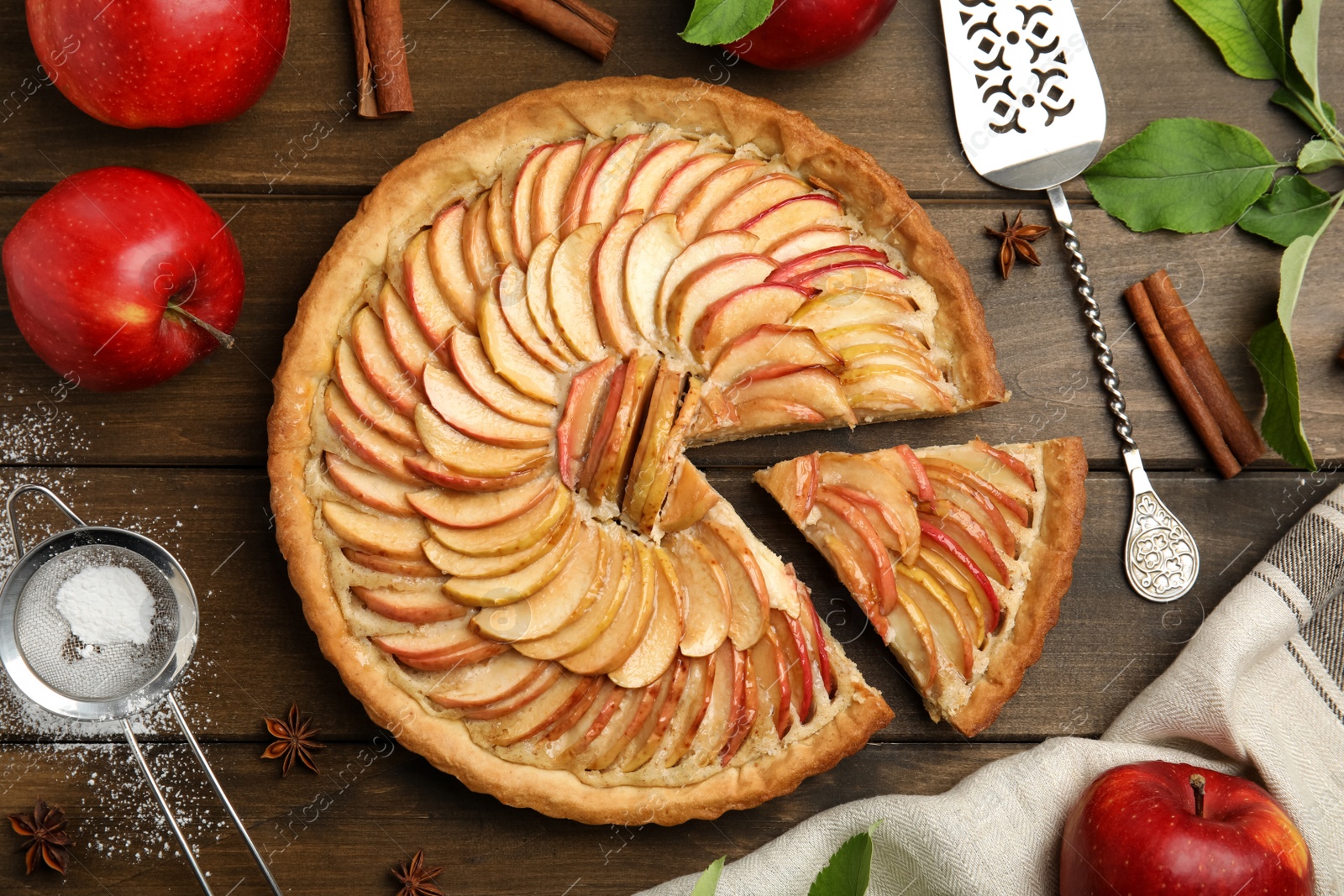 Photo of Delicious apple pie and ingredients on wooden table, flat lay