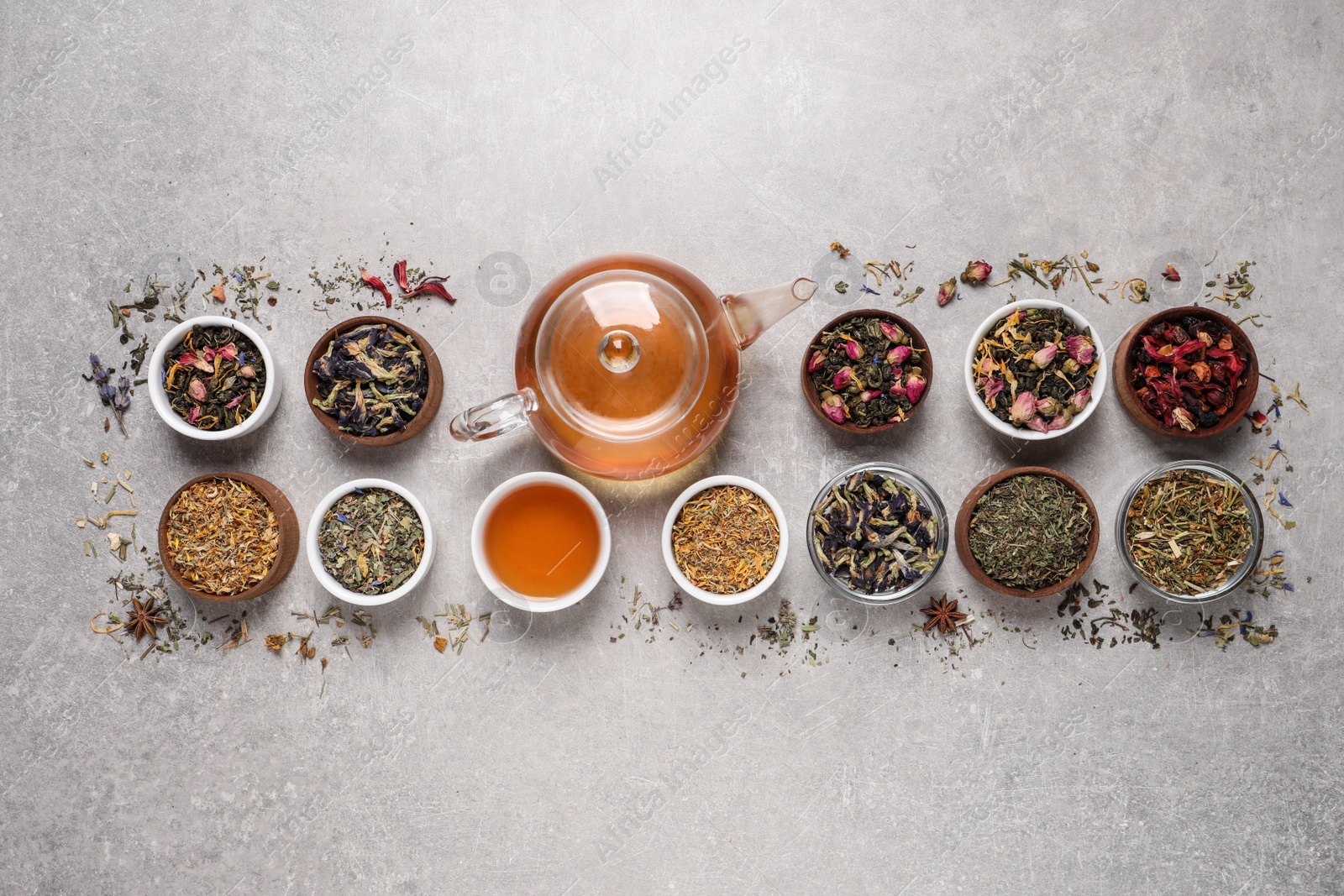 Photo of Flat lay composition with different dry teas and hot drink on light table