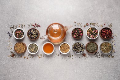 Flat lay composition with different dry teas and hot drink on light table