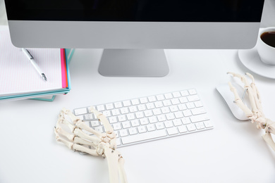 Human skeleton at table in office, closeup