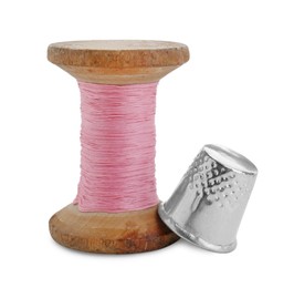 Photo of Thimble and spool of sewing thread isolated on white