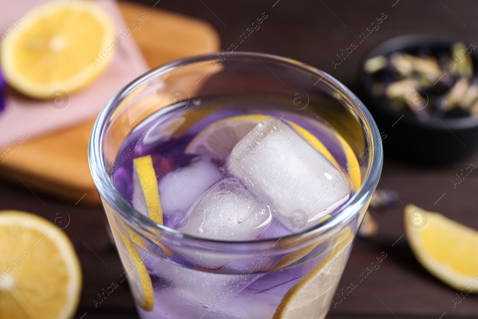 Photo of Organic blue Anchan with lemon in glass on table, closeup. Herbal tea