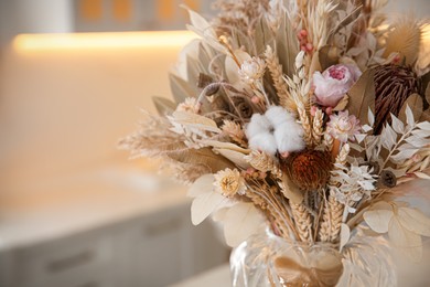 Photo of Bouquet of dry flowers and leaves in kitchen. Space for text