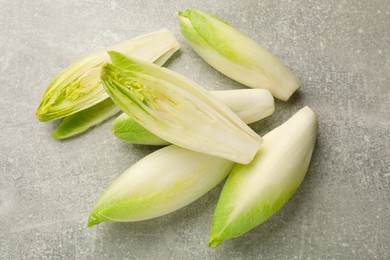 Photo of Fresh raw Belgian endives (chicory) on light grey table, top view