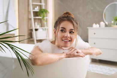Beautiful woman enjoying bubble bath at home