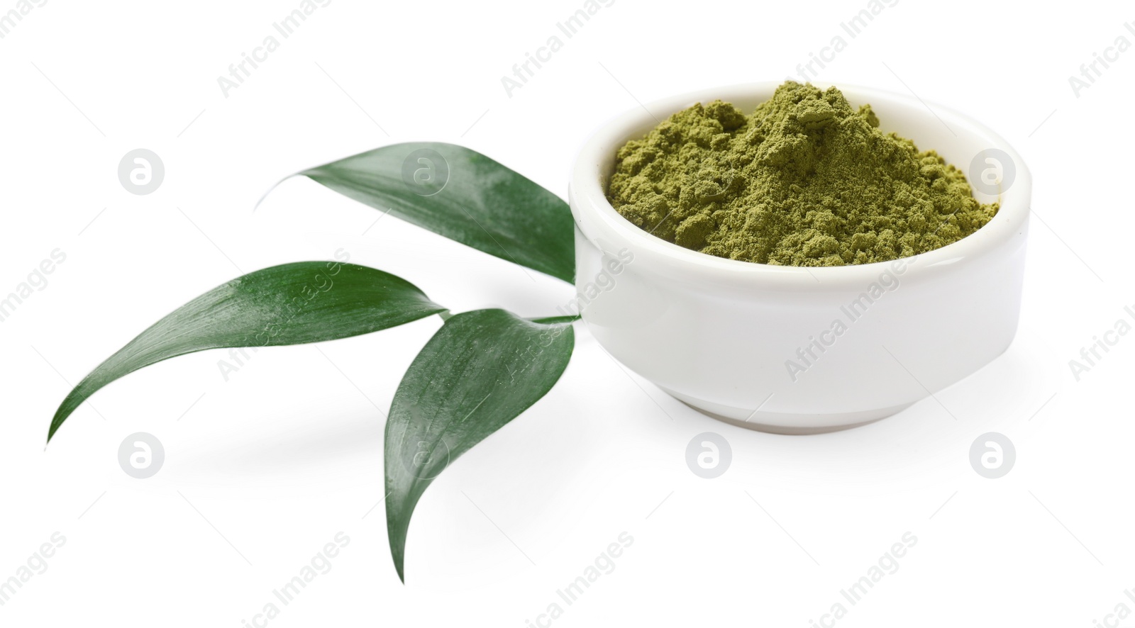 Photo of Henna powder in bowl and green leaves isolated on white