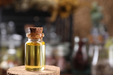 Photo of Bottle with herbal essential oils on blurred background. Space for text