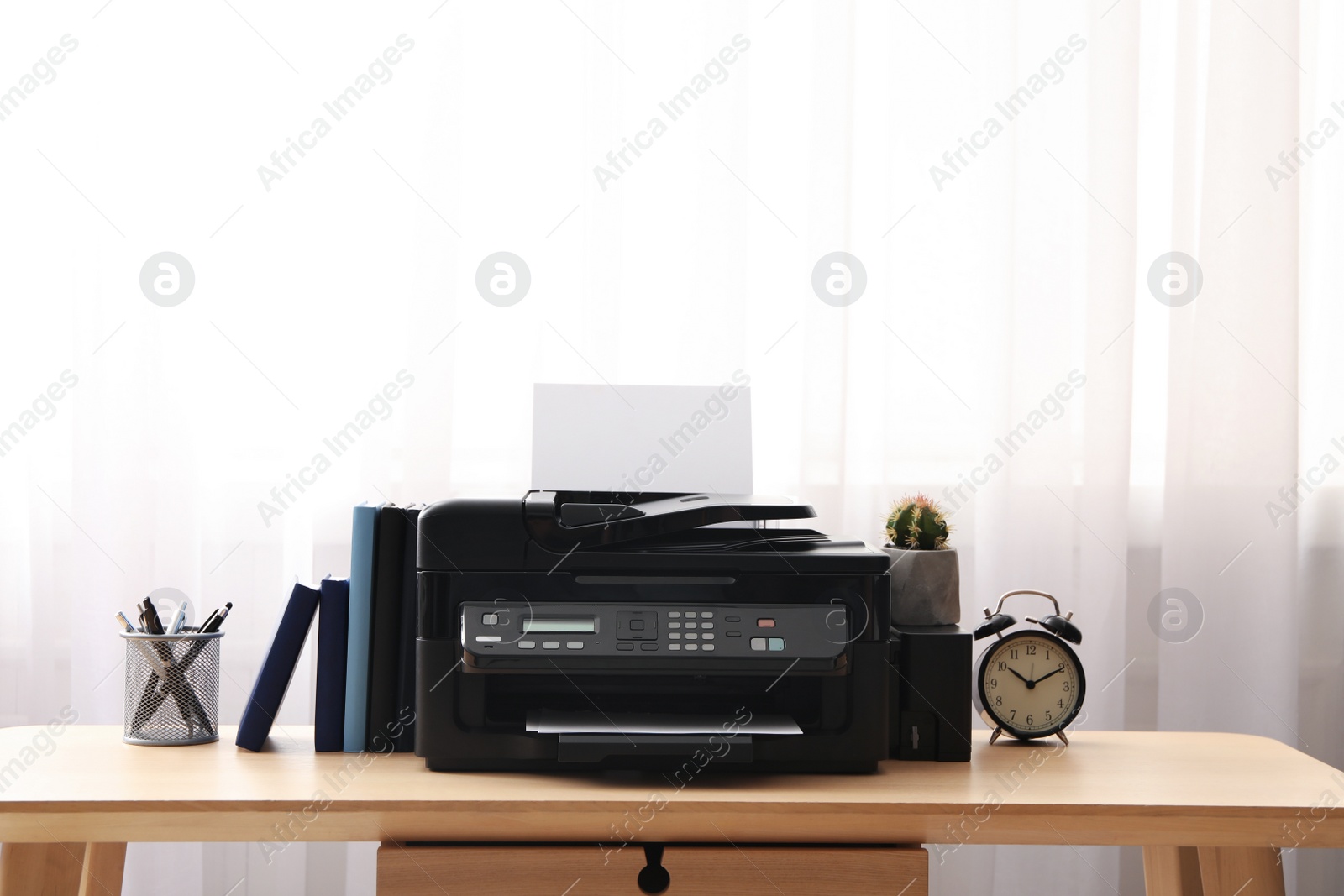 Photo of Modern printer and office supplies on wooden table indoors