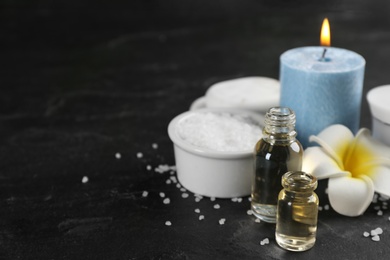 Photo of Beautiful spa composition with essential oil and candle on black table. Space for text