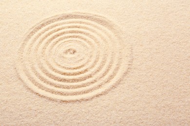 Photo of Zen rock garden. Circle pattern on beige sand