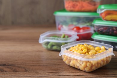 Photo of Set of plastic containers with fresh food on wooden  table, space for text