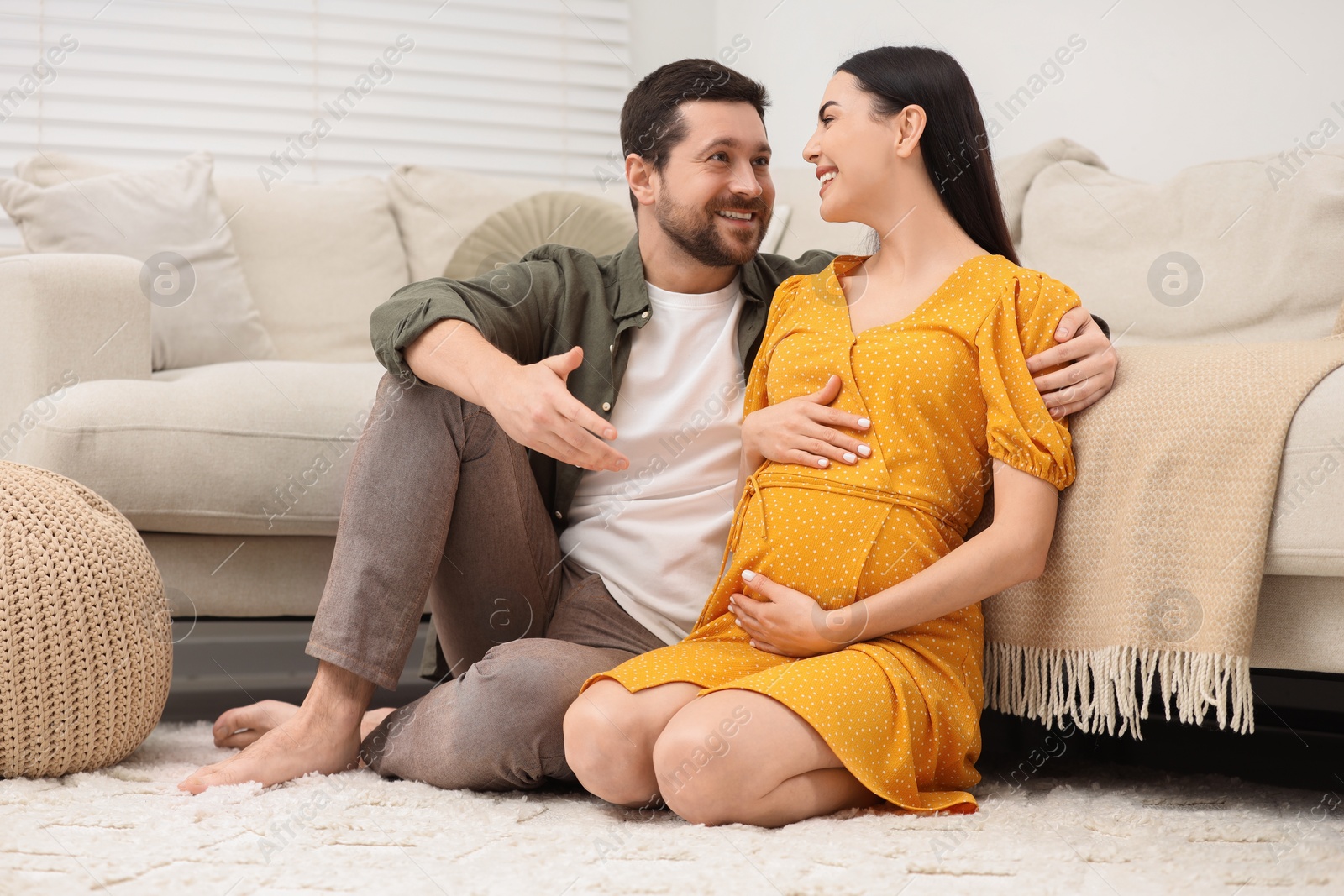 Photo of Happy pregnant woman spending time with her husband at home