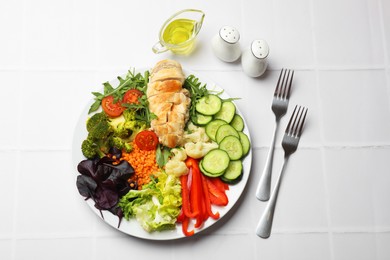 Photo of Balanced diet and healthy foods. Plate with different delicious products on white tiled table, flat lay