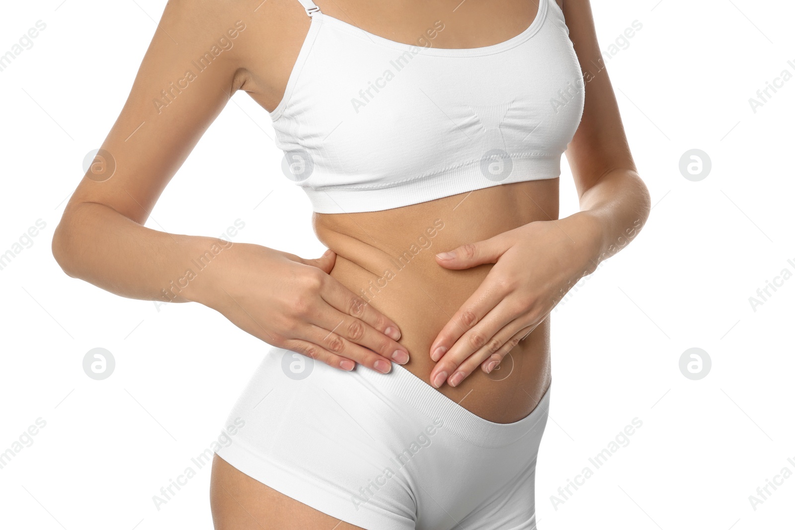 Photo of Young woman drawing attention to waist on white background, closeup. Plastic surgery concept