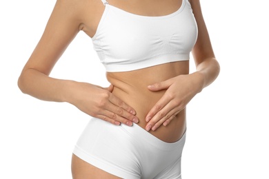 Photo of Young woman drawing attention to waist on white background, closeup. Plastic surgery concept