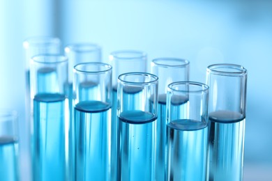 Photo of Test tubes with light blue liquid in laboratory, closeup