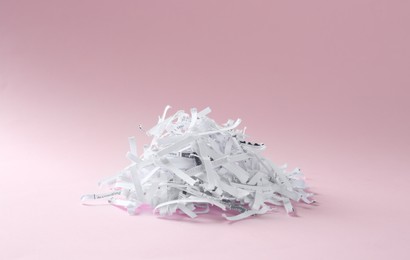 Photo of Heap of shredded paper strips on violet background