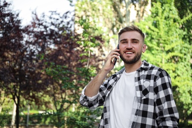 Young man talking on smartphone in park