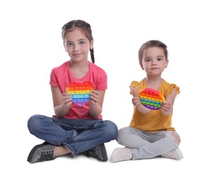 Photo of Little children with pop it fidget toys on white background
