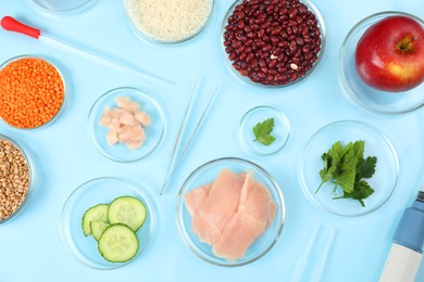 Photo of Food quality control. Petri dishes with different products, pipettes and tweezers on light blue background, flat lay