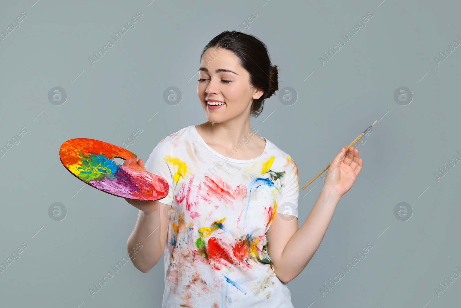 Photo of Woman with painting tools on grey background. Young artist