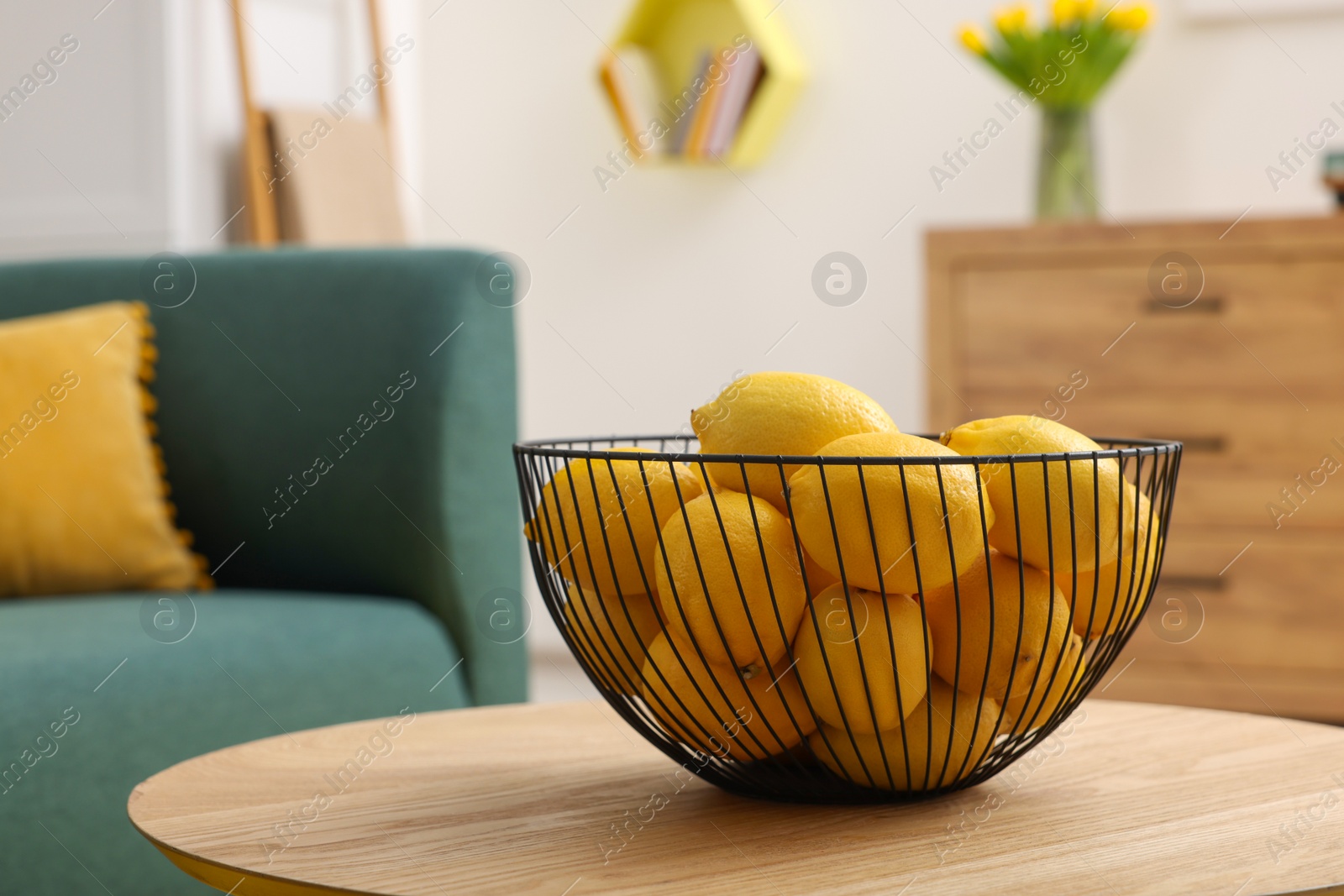 Photo of Spring interior. Bowl of lemons on wooden table in living room, space for text