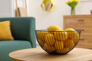 Spring interior. Bowl of lemons on wooden table in living room, space for text