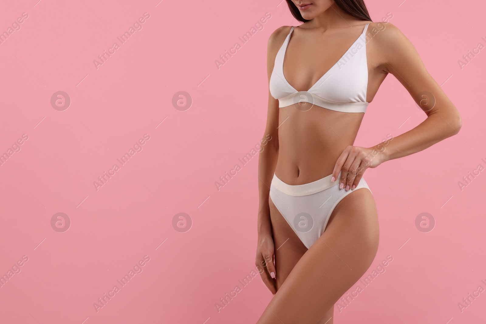 Photo of Young woman in stylish white bikini on pink background, closeup. Space for text