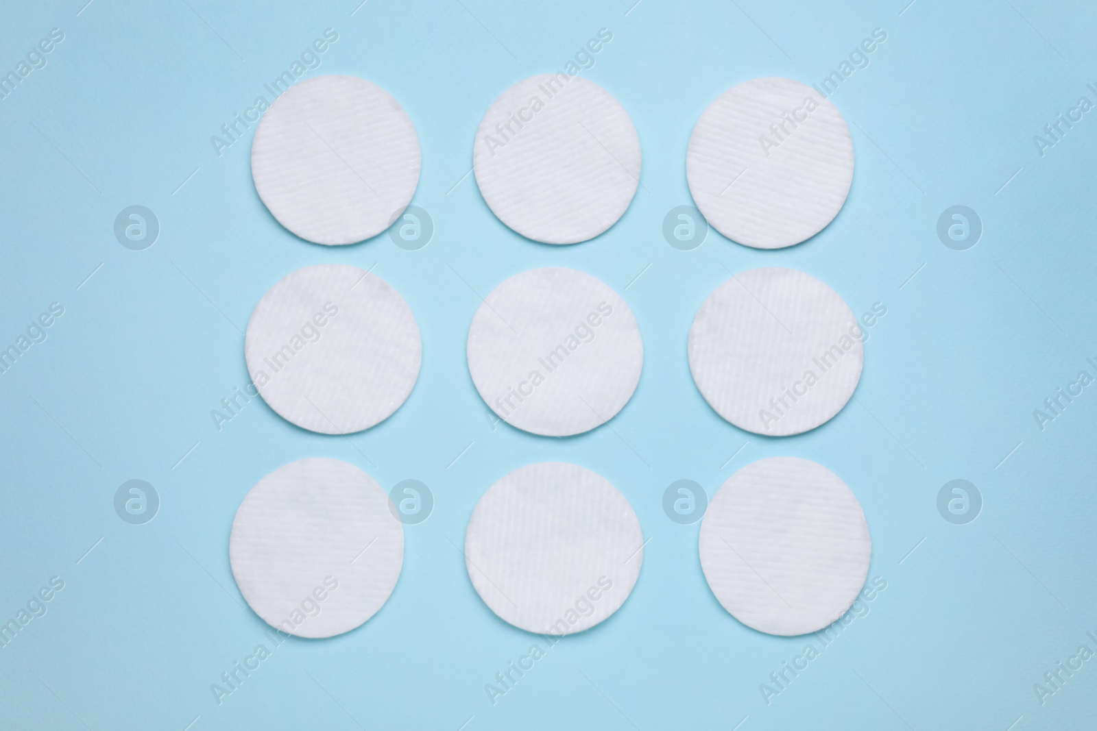 Photo of Many cotton pads on light blue background, flat lay
