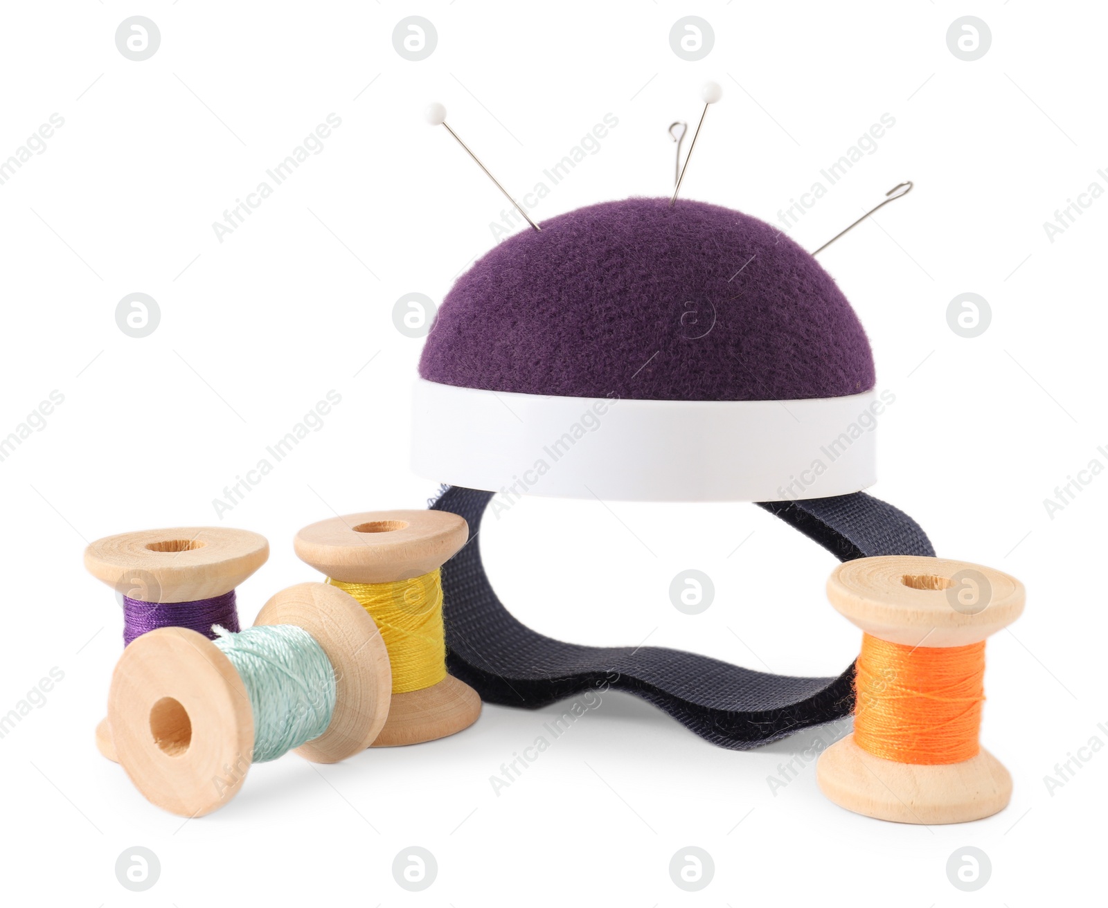 Photo of Pincushion, sewing needles, pins and spools with threads isolated on white