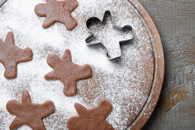 Photo of Making homemade Christmas cookies. Dough for gingerbread man on wooden table, top view