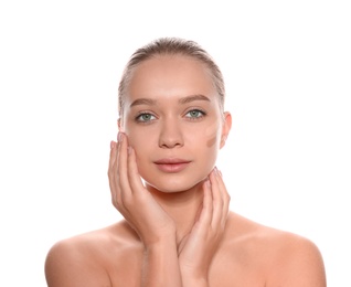 Photo of Young woman with different shades of skin foundation on her face against white background