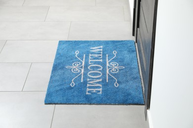 Photo of Beautiful doormat with word Welcome on floor near entrance