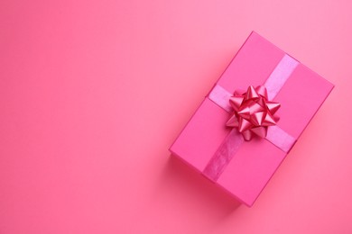 Photo of Beautiful gift box on pink background, top view. Space for text