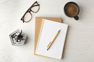 Photo of Flat lay composition with office stationery and cup of coffee on white wooden table