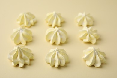 Delicious meringue cookies on beige background, closeup