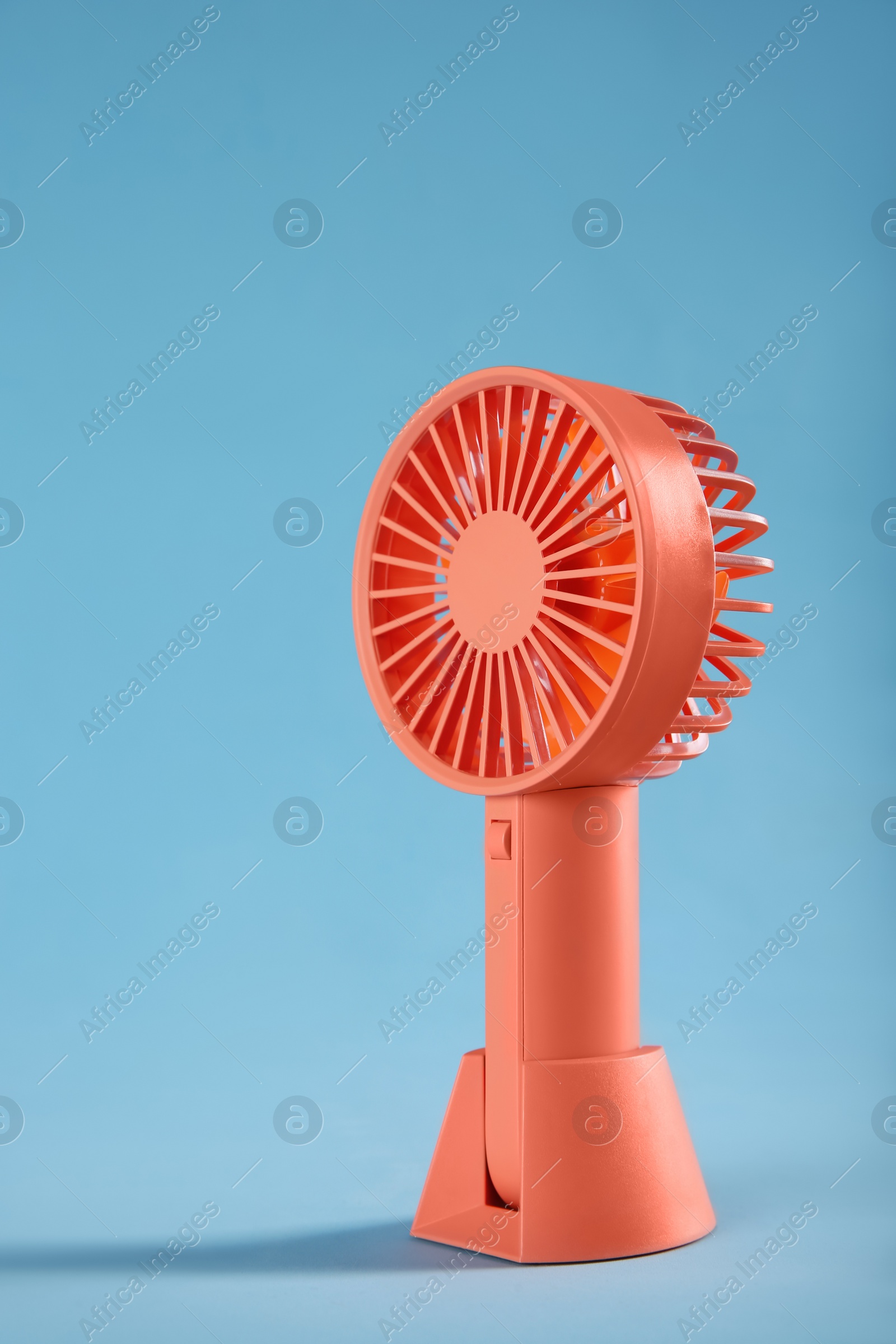Photo of Modern electric fan on light blue background